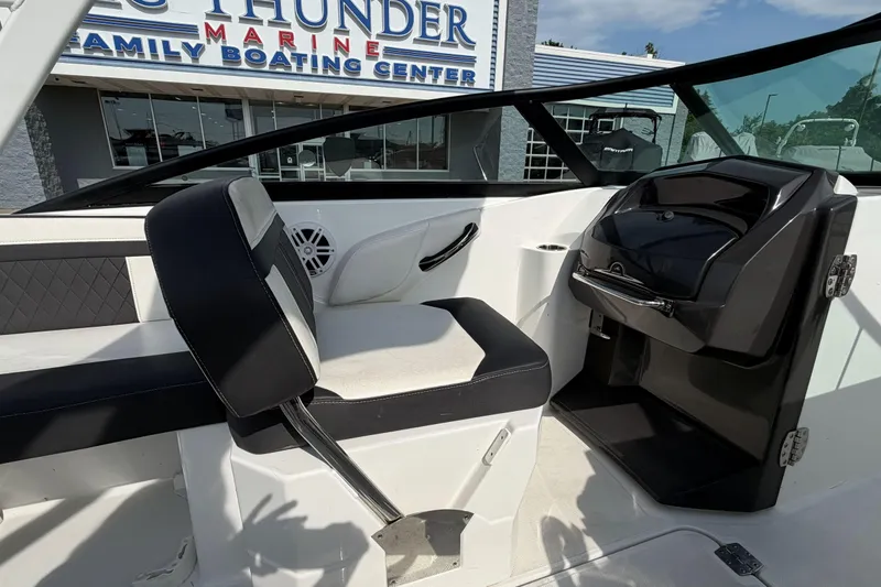 Slide: The Image of 2022 Monterey M4 boat interior with seating and dashboard at a marine center. - 29