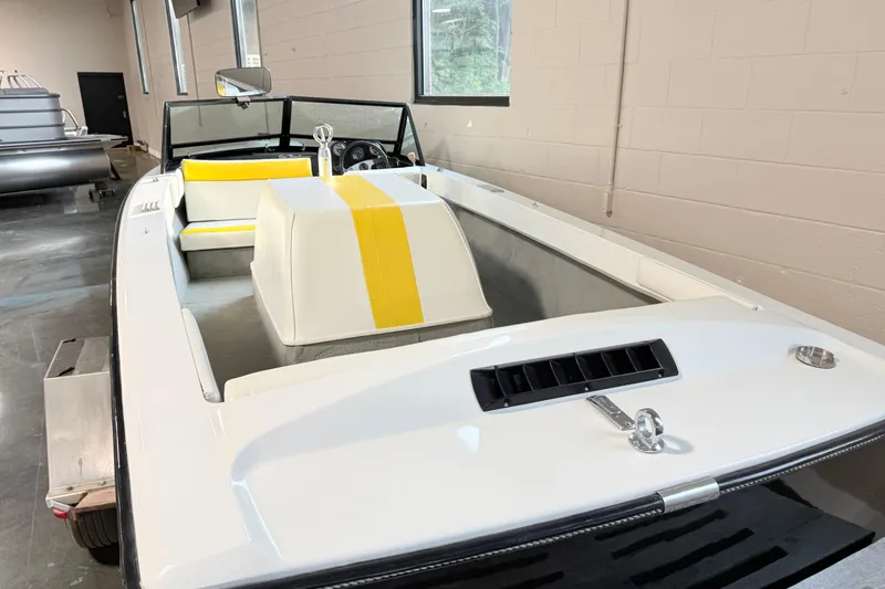 Slide: The Image of 1978 Correct Craft Ski Nautique boat with yellow-striped seats in a showroom. - 4