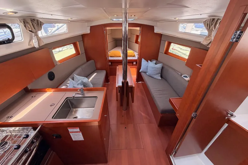 Slide: The Image of Interior of 2018 Beneteau Oceanis 35.1 yacht with modern kitchen and cozy seating area. - 36