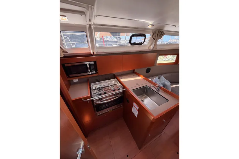 Slide: The Image of Interior of 2018 Beneteau Oceanis 35.1 yacht kitchen with stove, sink, and microwave. - 39