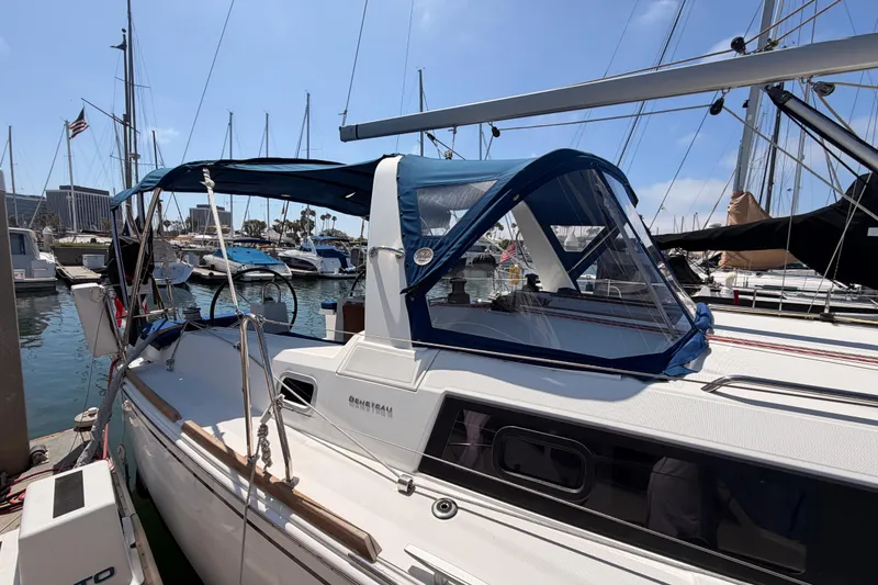 Slide: The Image of 2018 Beneteau Oceanis 35.1 sailboat docked at marina, featuring blue canopy and sleek design. - 7