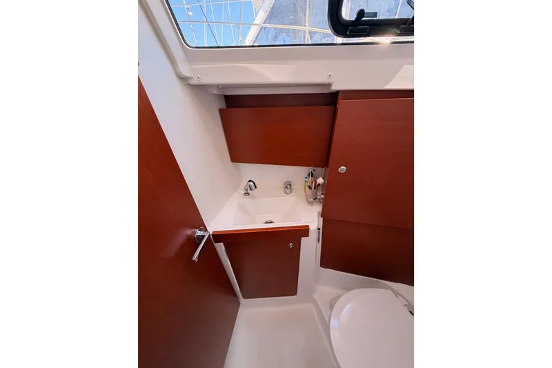 Slide: The Image of Interior of 2018 Beneteau Oceanis 35.1 yacht bathroom with wooden cabinetry and sink. - 54