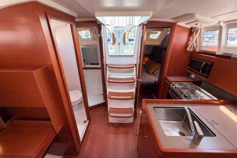 Slide: The Image of Interior of 2018 Beneteau Oceanis 35.1 yacht, featuring kitchen, bathroom, and cozy cabin. - 68