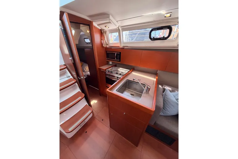 Slide: The Image of Interior of 2018 Beneteau Oceanis 35.1 yacht featuring modern kitchen and cozy seating area. - 37