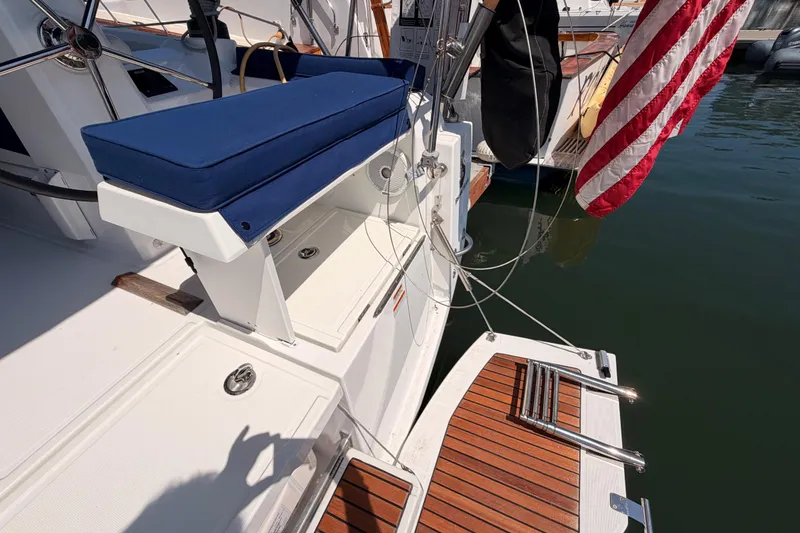 Slide: The Image of 2018 Beneteau Oceanis 35.1 yacht stern with blue seating and American flag. - 22