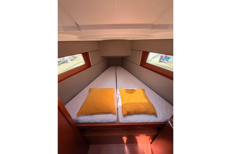 Slide: The Image of Cozy cabin interior of 2018 Beneteau Oceanis 35.1 with twin beds and yellow pillows. - 62