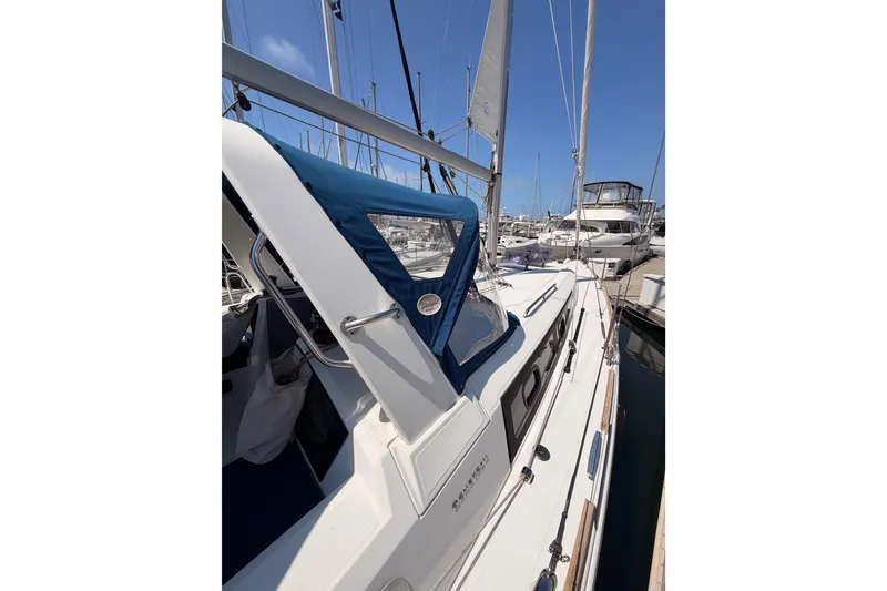 Slide: The Image of 2018 Beneteau Oceanis 35.1 sailboat docked at marina, featuring blue canopy and sleek design. - 10