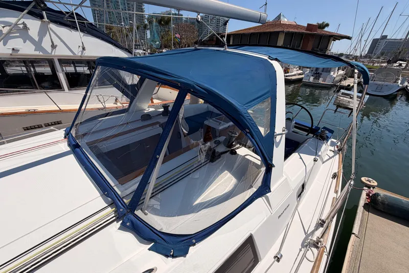 Slide: The Image of 2018 Beneteau Oceanis 35.1 sailboat with blue canopy docked at marina. - 17