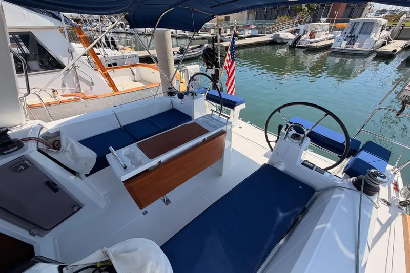 Slide: The Image of 2018 Beneteau Oceanis 35.1 sailboat cockpit with dual steering wheels, docked at marina. - 18