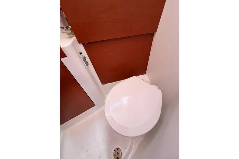 Slide: The Image of Beneteau Oceanis 35.1 2018 yacht bathroom with compact toilet and wooden paneling. - 53