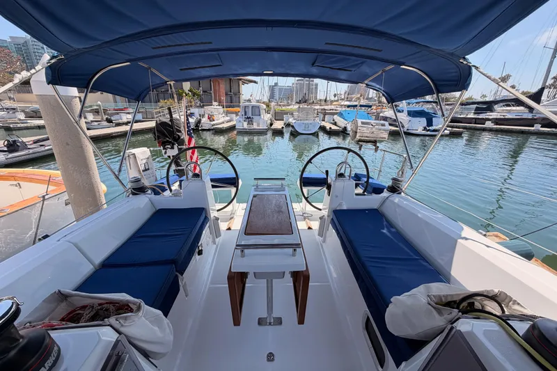 Slide: The Image of 2018 Beneteau Oceanis 35.1 yacht interior with blue seating, docked at marina. - 19