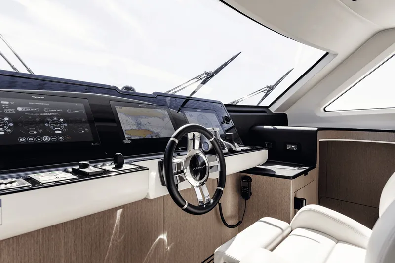 Slide: The Image of The cockpit of the 2027 Azimut Grande 26M features a modern helm with multiple screens and a sleek steering wheel. - 41
