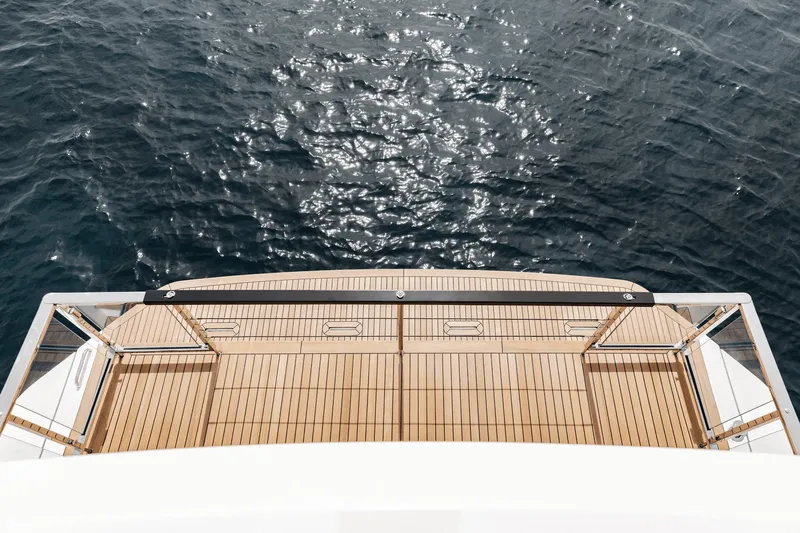 Slide: The Image of The 2027 Azimut Grande 26M features an elegant teak deck over calm water. - 29