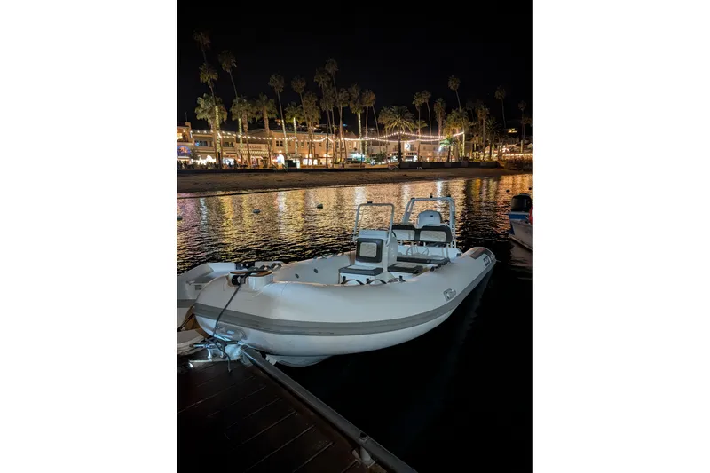 Slide: The Image of Tide Craft Kodiak 16 boat docked at night, reflecting city lights on water. - 14