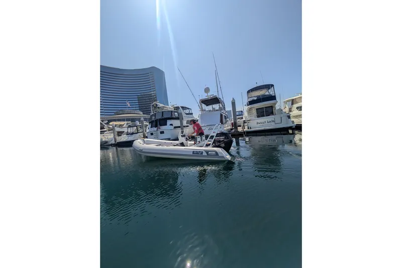 Slide: The Image of 2027 Tide Craft Kodiak 16 boat docked in marina with modern buildings in background. - 13
