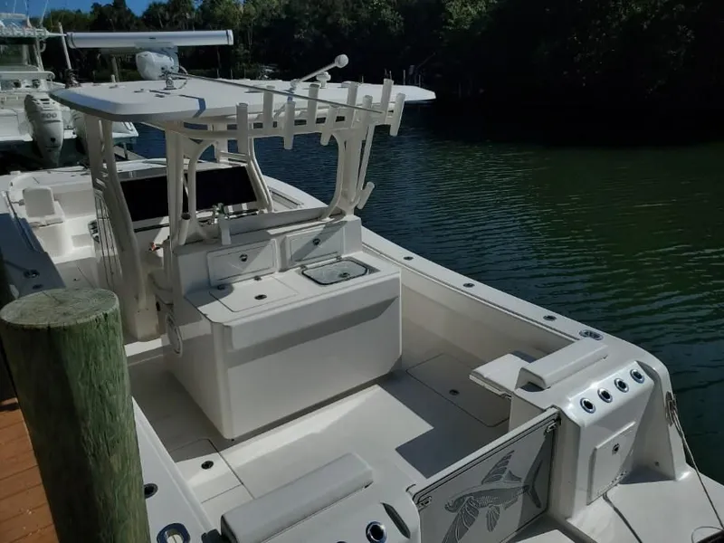Slide: The Image of A modern 2022 Calcutta 323 docked in a serene setting. The boat features a spacious deck. - 2