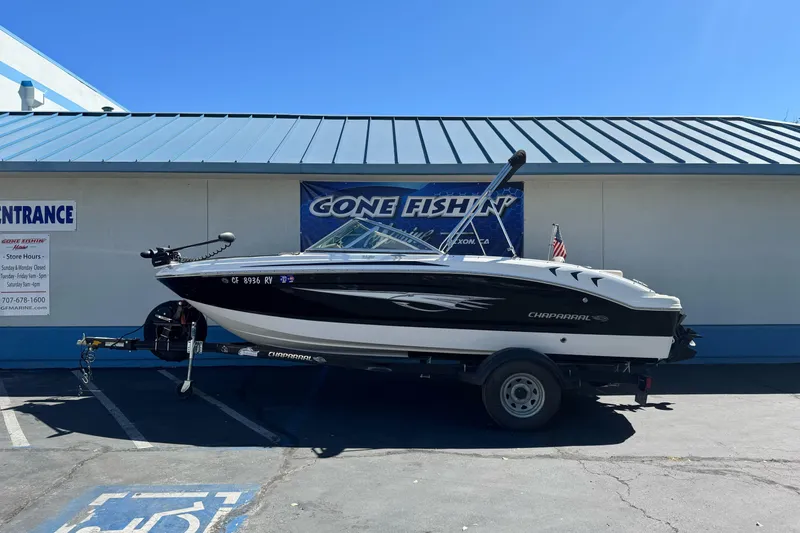 The Image of 2018 Chaparral 19 H2O Ski & Fish boat on trailer outside a store. - 1