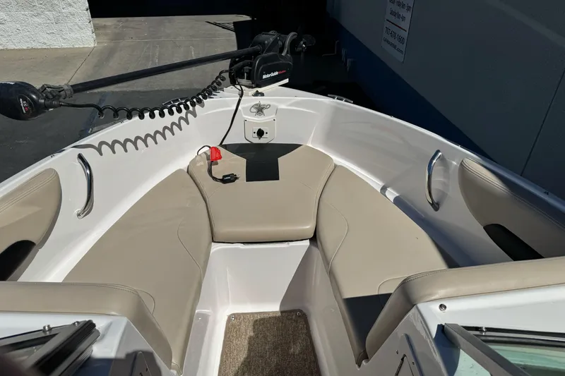 Slide: The Image of 2018 Chaparral 19 H2O Ski & Fish boat interior with beige seating and trolling motor. - 20