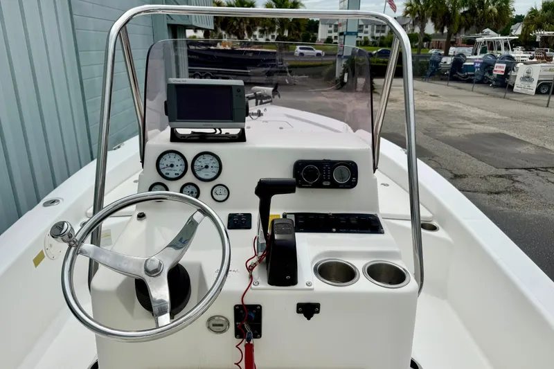 Slide: The Image of 2005 BlackJack 224 boat dashboard with steering wheel, gauges, and navigation equipment. - 5