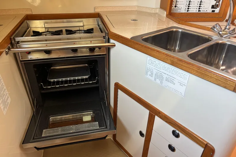 Slide: The Image of Galley kitchen with stove, oven, and double sink. - 15