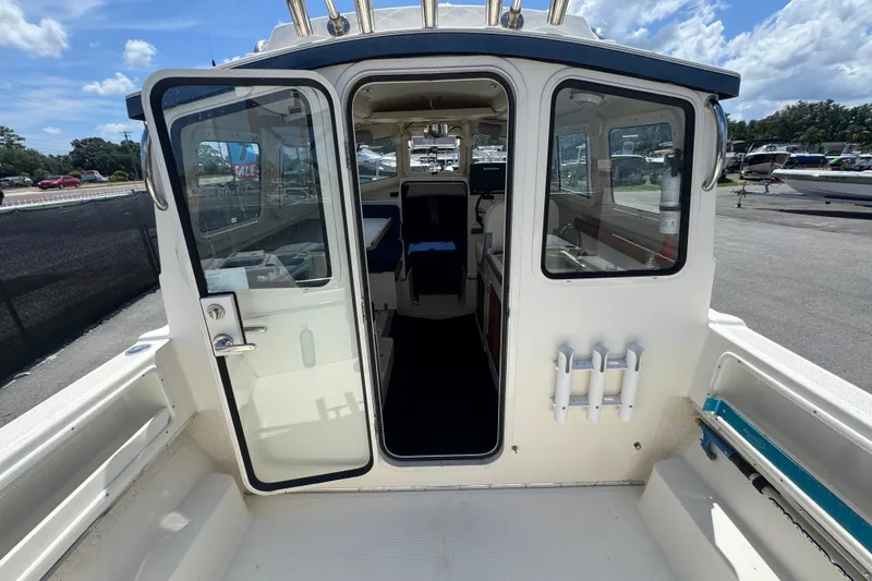 Slide: The Image of 2013 C-Dory 22' Cruiser boat interior view with open cabin door. - 23