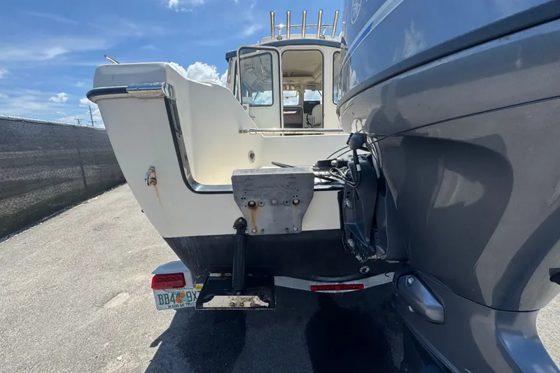 Slide: The Image of 2013 C-Dory 22' Cruiser boat with outboard motor, parked on a sunny day. - 9