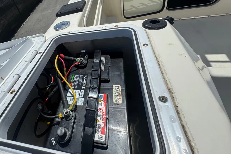 Slide: The Image of 2013 C-Dory 22' Cruiser boat battery compartment with open hatch, showcasing wiring and connections. - 50