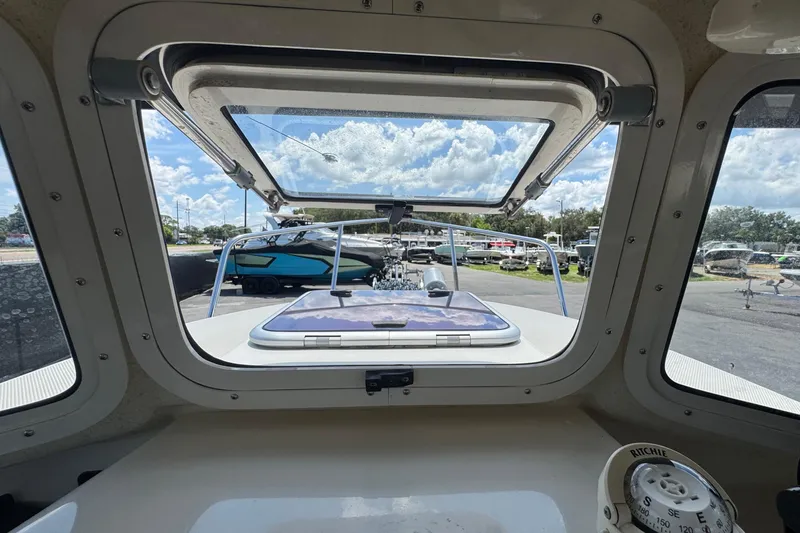 Slide: The Image of Interior view of a 2013 C-Dory 22' Cruiser boat with open hatch and compass. - 31