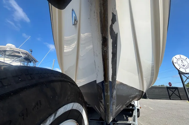 Slide: The Image of 2013 C-Dory 22' Cruiser boat hull on trailer, showing wear and damage. - 7