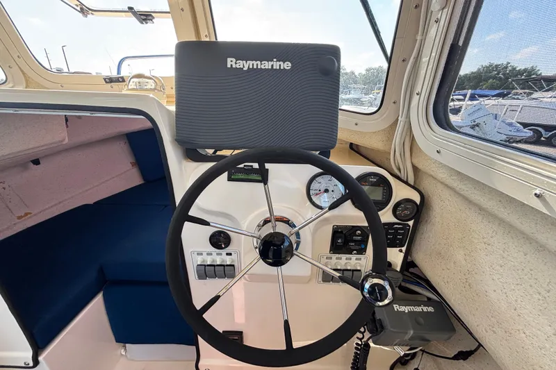 Slide: The Image of 2013 C-Dory 22' Cruiser helm with Raymarine navigation system and steering wheel. - 18