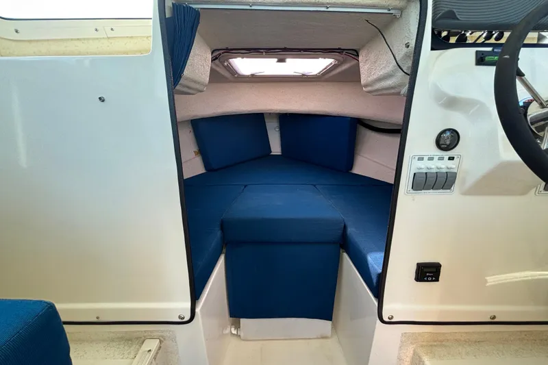 Slide: The Image of Interior cabin of a 2013 C-Dory 22' Cruiser with blue cushions and steering controls. - 19