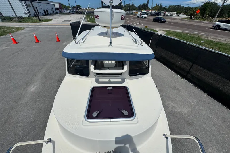 Slide: The Image of 2013 C-Dory 22' Cruiser boat on pavement, featuring a rooftop radar and hatch. - 17