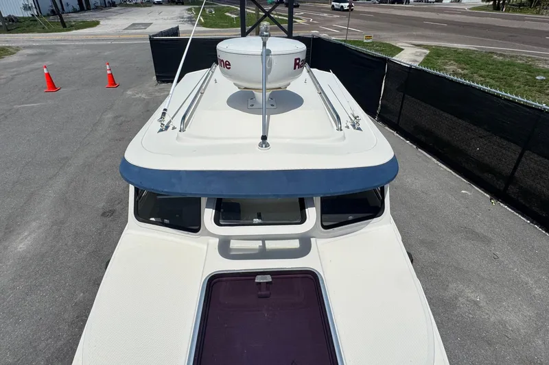 Slide: The Image of 2013 C-Dory 22' Cruiser boat parked, showcasing roof and radar equipment. - 18