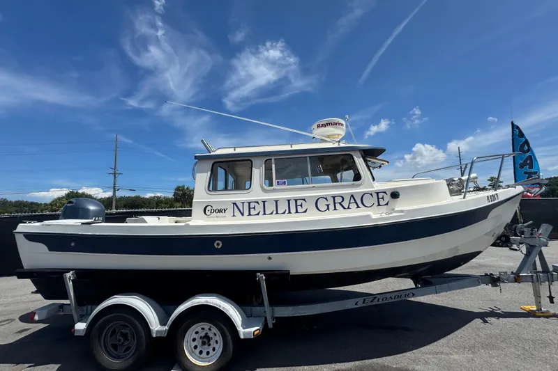 Slide: The Image of 2013 C-Dory 22' Cruiser boat named "Nellie Grace" on trailer under blue sky. - 1