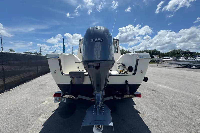 Slide: The Image of 2013 C-Dory 22' Cruiser with 115 HP outboard motor, parked under a clear blue sky. - 4