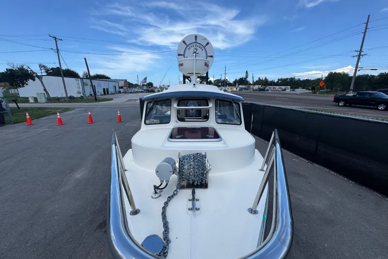 Slide: The Image of 2013 C-Dory 22' Cruiser boat with anchor chain, parked on a street. - 16