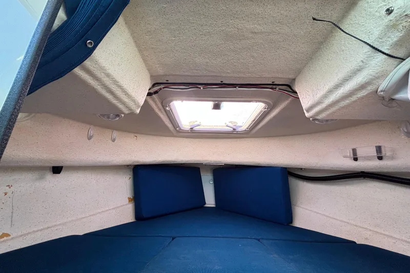 Slide: The Image of Interior cabin of a 2013 C-Dory 22' Cruiser with blue cushions and overhead hatch. - 21