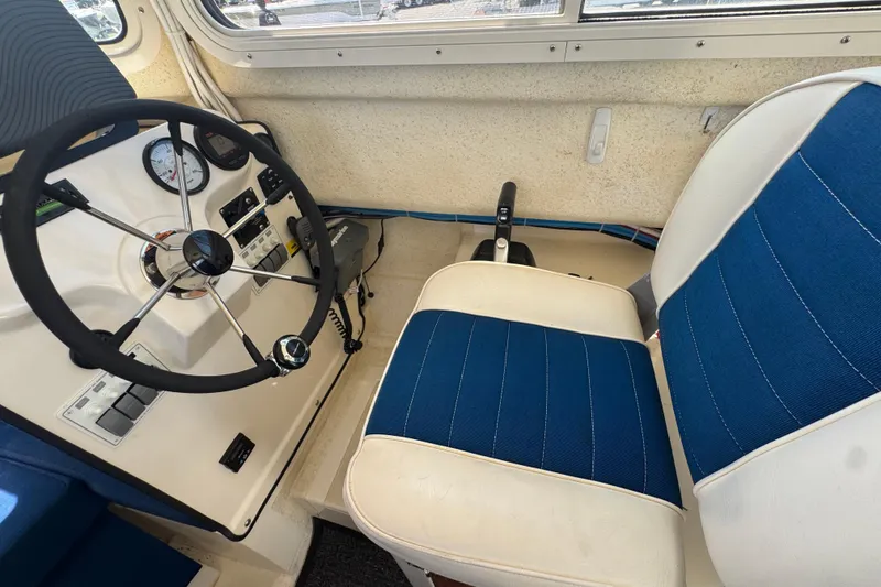Slide: The Image of Interior of a 2013 C-Dory 22' Cruiser with blue and white seating. - 33