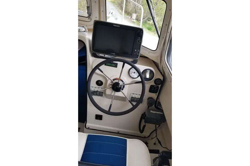 Slide: The Image of 2013 C-Dory 22' Cruiser helm with steering wheel and navigation equipment. - 8