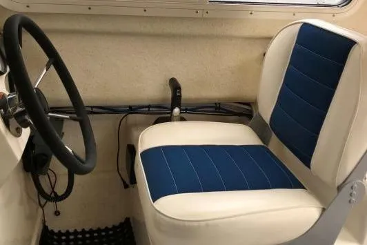 Slide: The Image of Interior of a 2013 C-Dory 22' Cruiser with blue and white seating. - 6