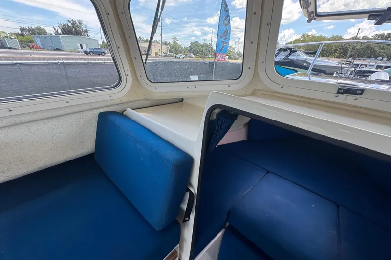 Slide: The Image of Interior of a 2013 C-Dory 22' Cruiser with blue seating and windows. - 44