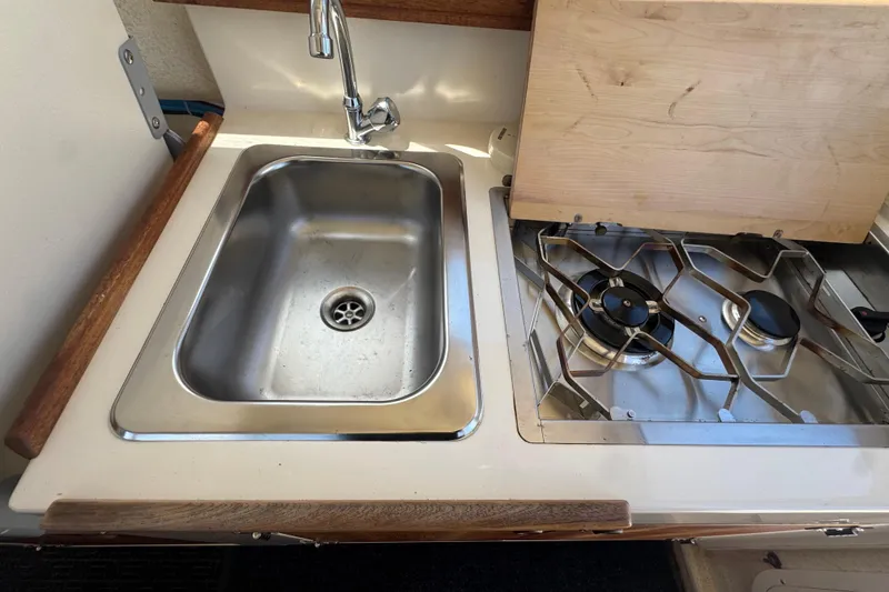 Slide: The Image of The galley of a 2013 C-Dory 22' Cruiser features a stainless steel sink and a two-burner stove. - 27