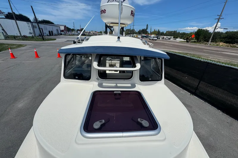 Slide: The Image of 2013 C-Dory 22' Cruiser boat on pavement, showcasing cabin and hatch. - 20