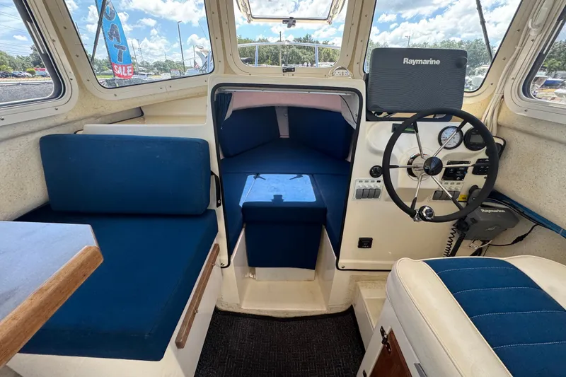 Slide: The Image of Interior of a 2013 C-Dory 22' Cruiser with blue seating and navigation equipment. - 29