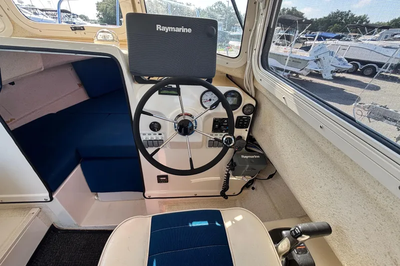 Slide: The Image of Interior of a 2013 C-Dory 22' Cruiser boat with steering wheel and Raymarine equipment. - 17