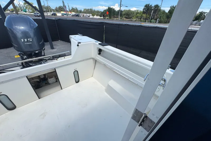 Slide: The Image of 2013 C-Dory 22' Cruiser boat deck with Yamaha 115 engine in a marina setting. - 48