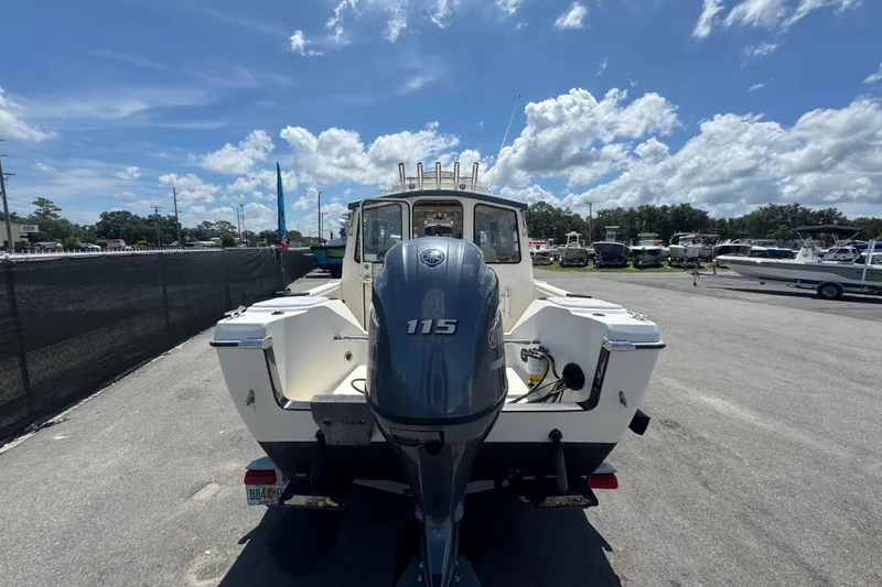 Slide: The Image of 2013 C-Dory 22' Cruiser with 115 HP outboard motor, parked under a sunny sky. - 3