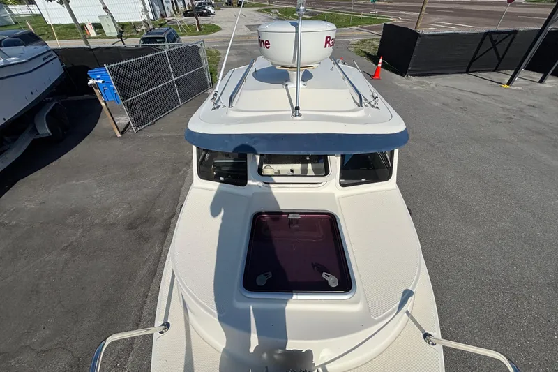 Slide: The Image of 2013 C-Dory 22' Cruiser boat with radar dome, parked on asphalt. - 27