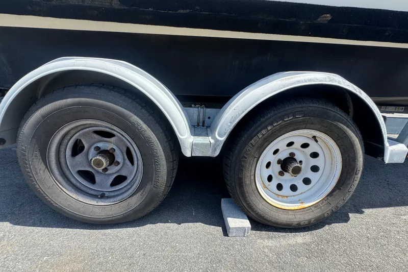 Slide: The Image of Trailer wheels of a 2013 C-Dory 22' Cruiser on pavement. - 56
