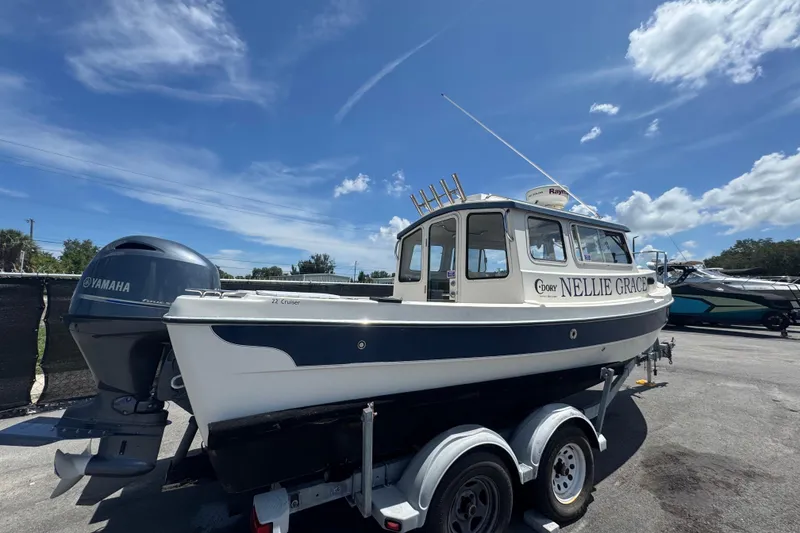 Slide: The Image of 2013 C-Dory 22' Cruiser boat on trailer with Yamaha engine under blue sky. - 2